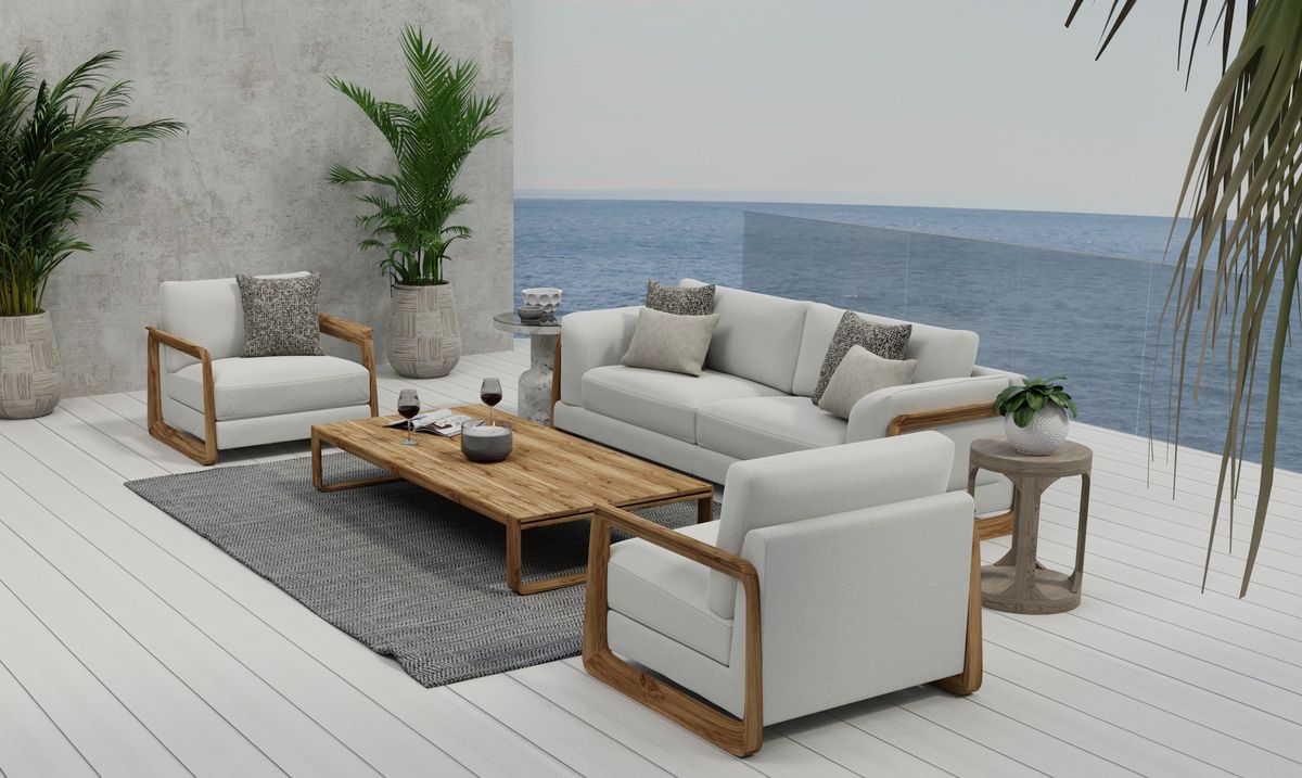 A set of modern outdoor couches on an airy terrace set against the backdrop of the sea.