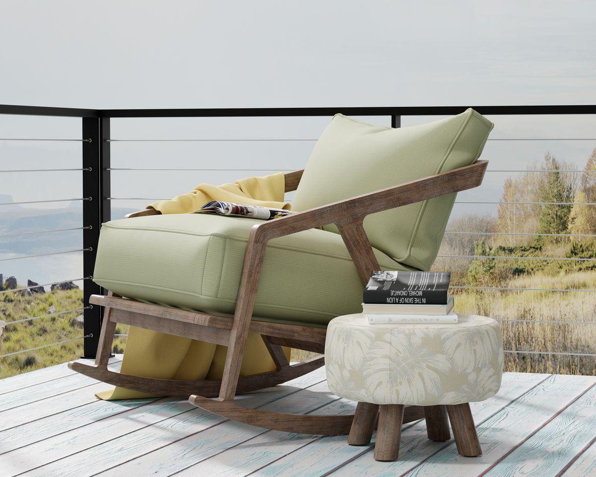 A modern outdoor recliner on a terrace set against the sea featuring fabrics from Outdura's Ovation 4 Collection.